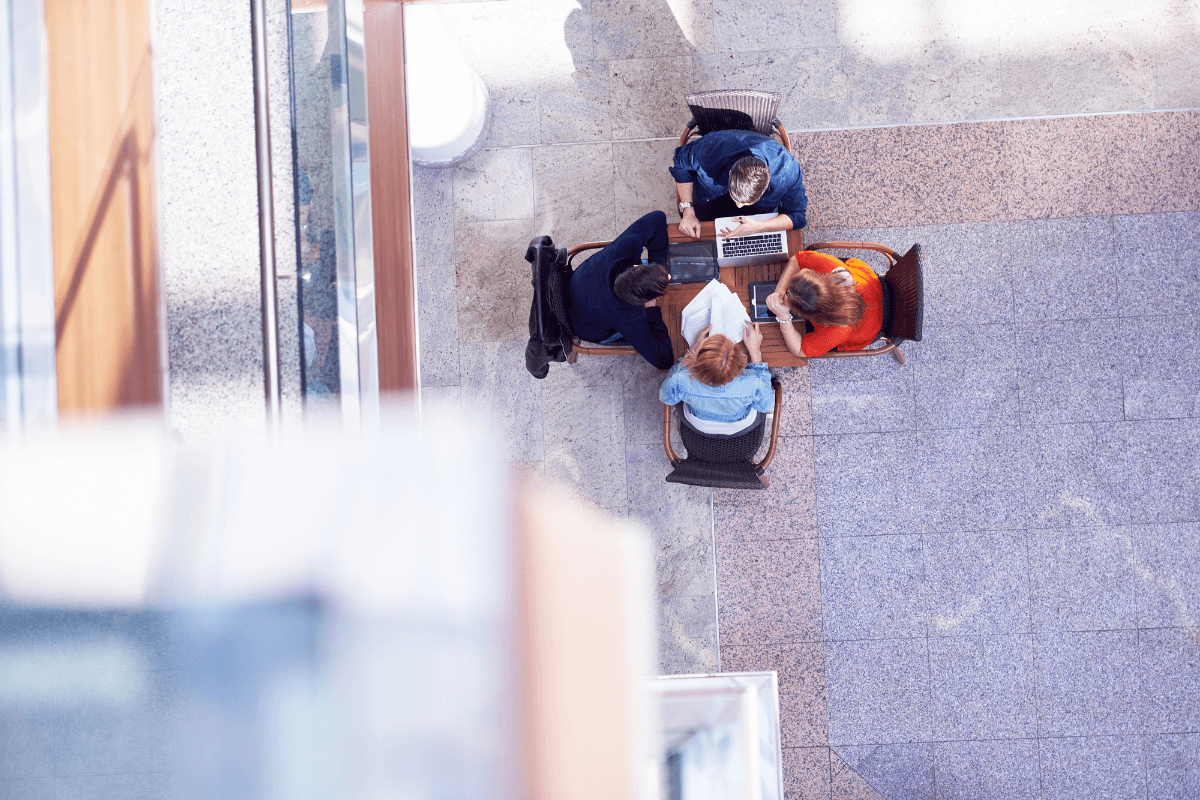 overhead shot of four people sitting around a small table