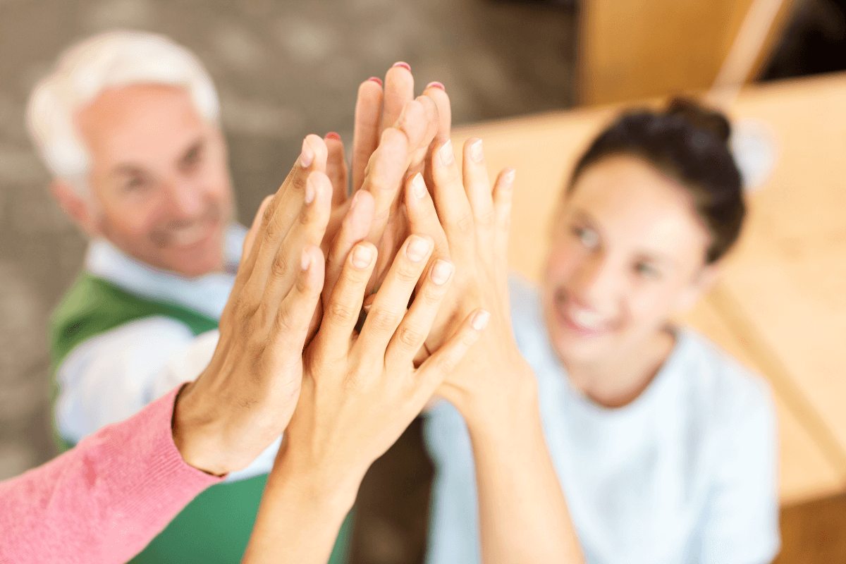 several adults raising their hands to high-five