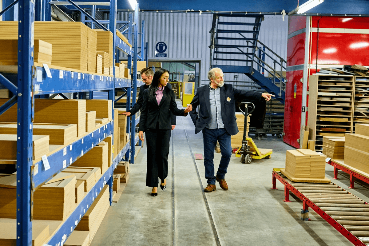 older woman and man walking in a packing facility