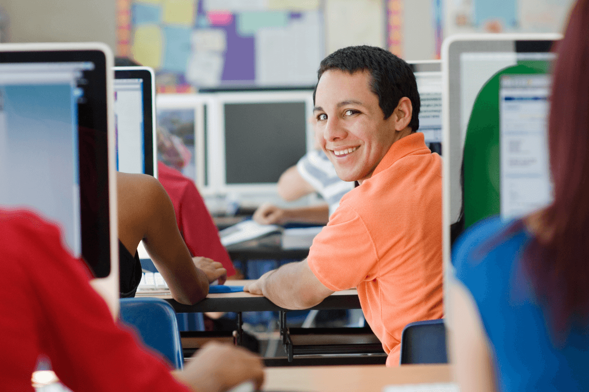 young man looking over his shoulder in a classroom