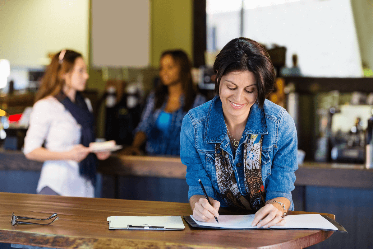 woman smiling and writing on a piece of paper