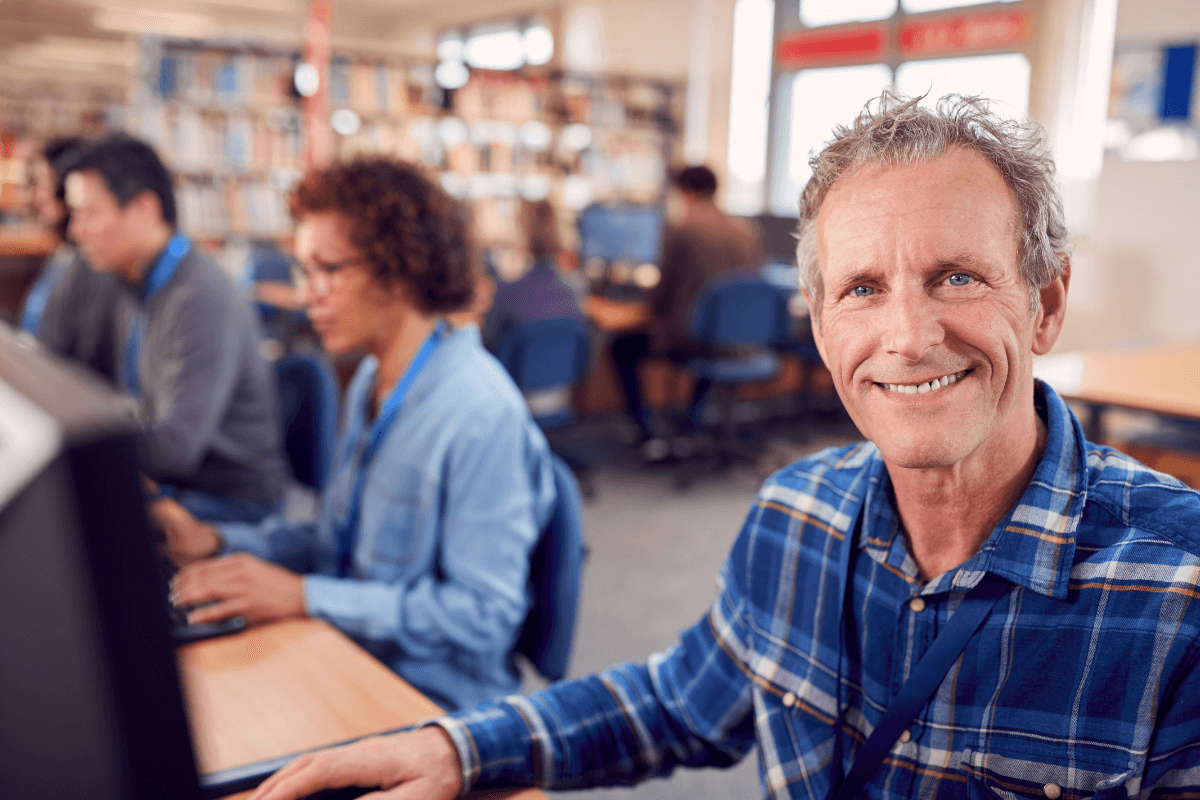 several adults working on computers in a public library