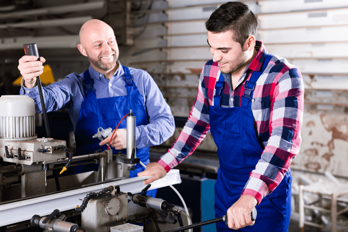 two men in work clothes at a manufacturing plant