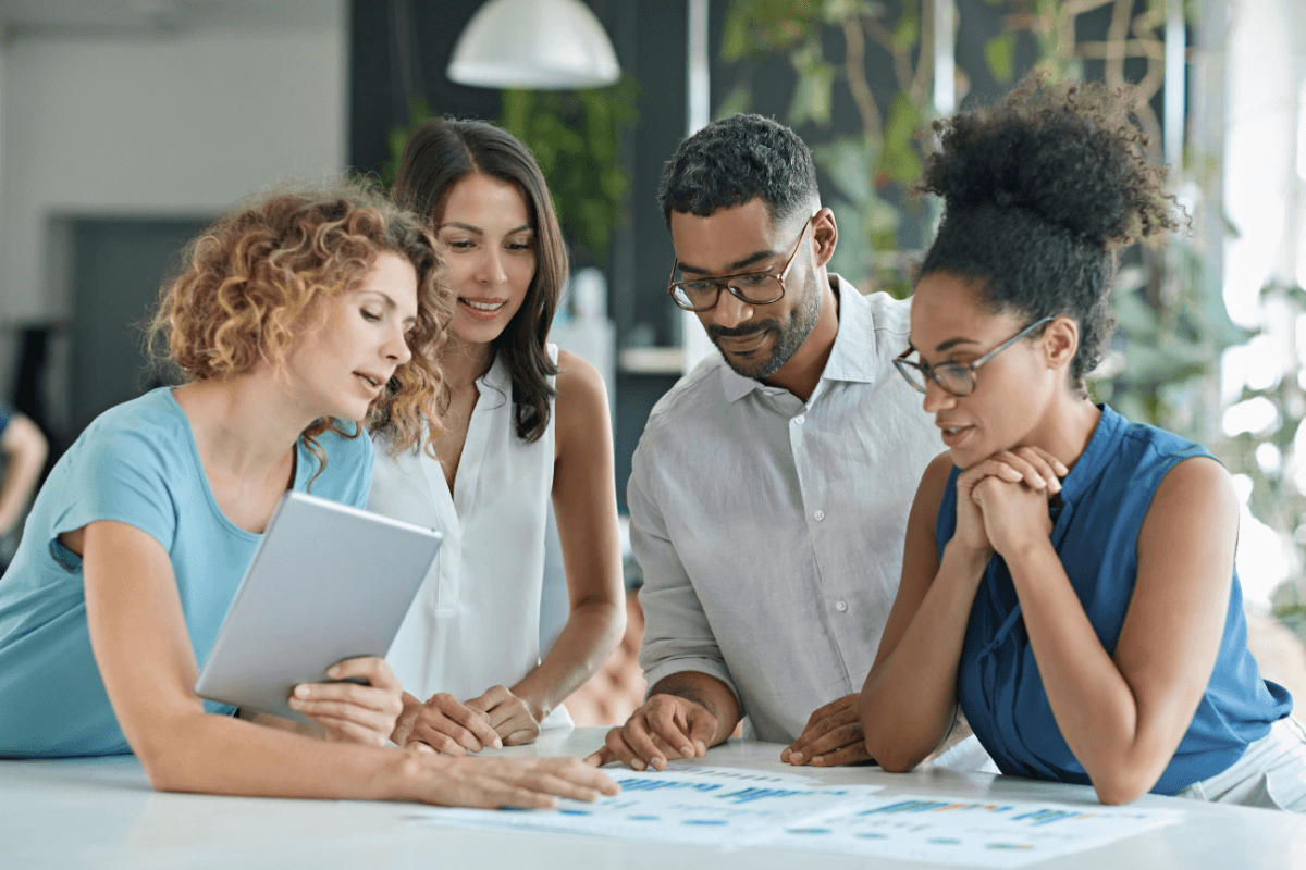 group of young professionals looking at reports on a table