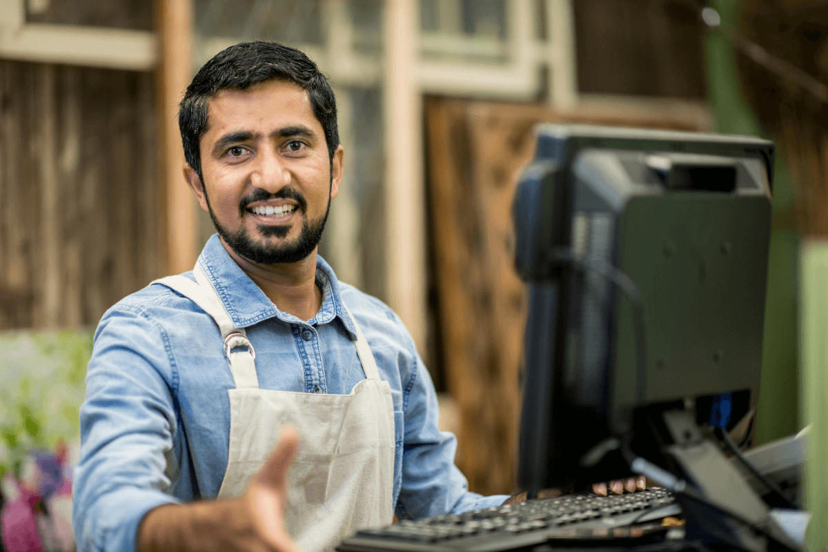 smiling man working the register at a store